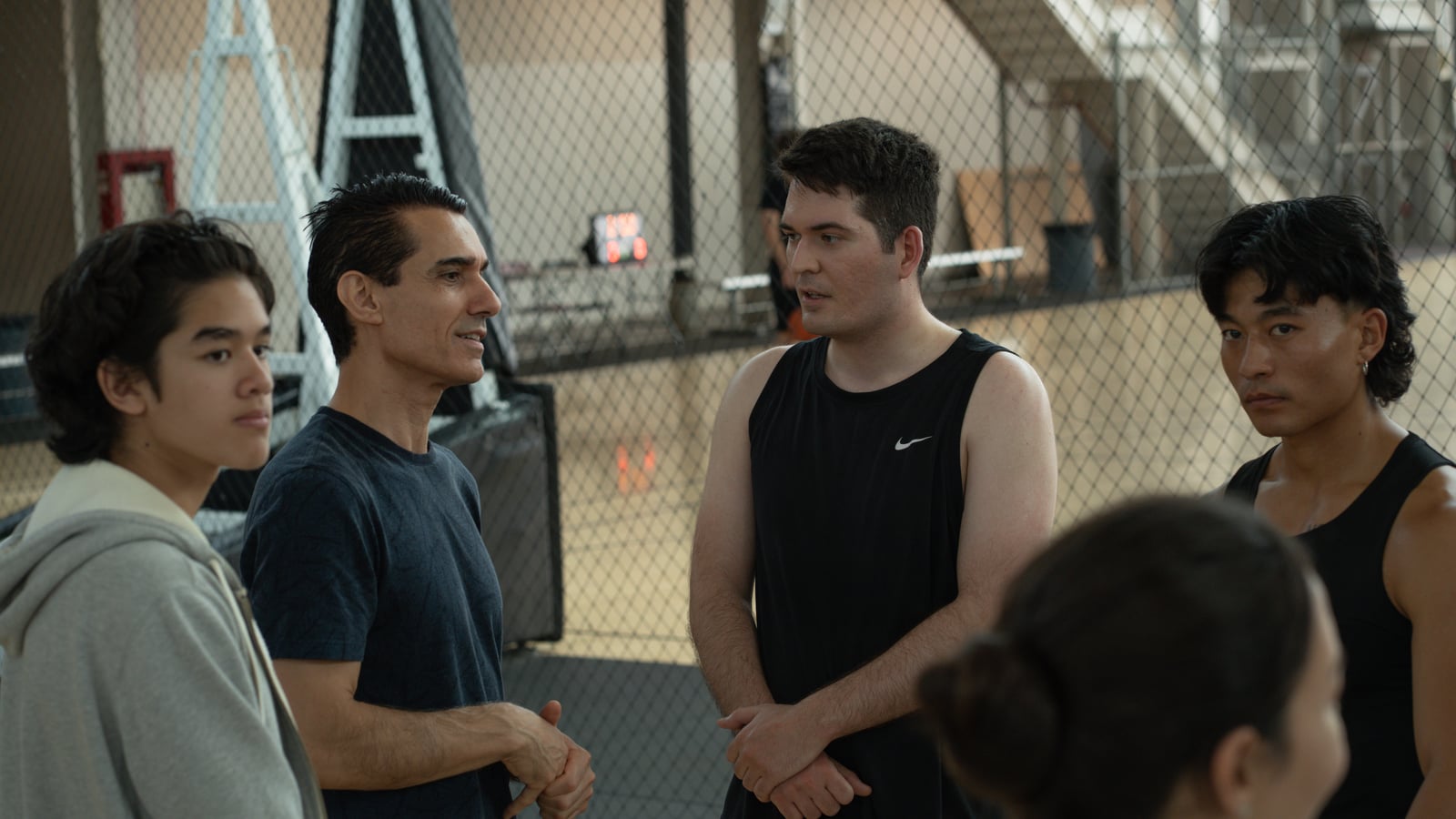 Sinan Erdemir chatting with young athletes at an indoor basketball court
