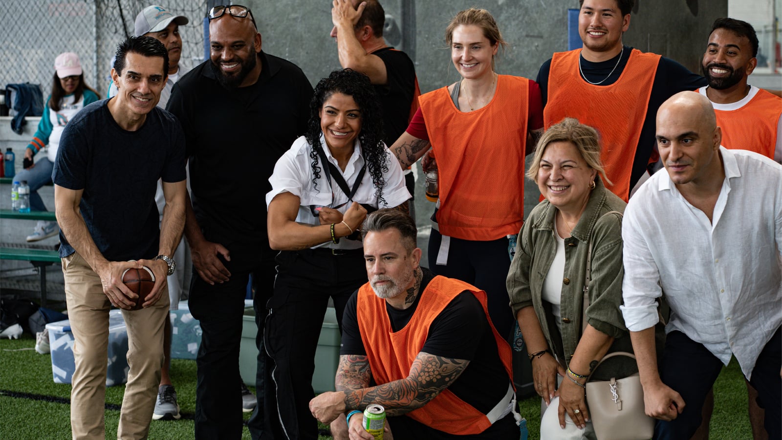 Sinan Erdemir posing with players and volunteers at a community flag football game