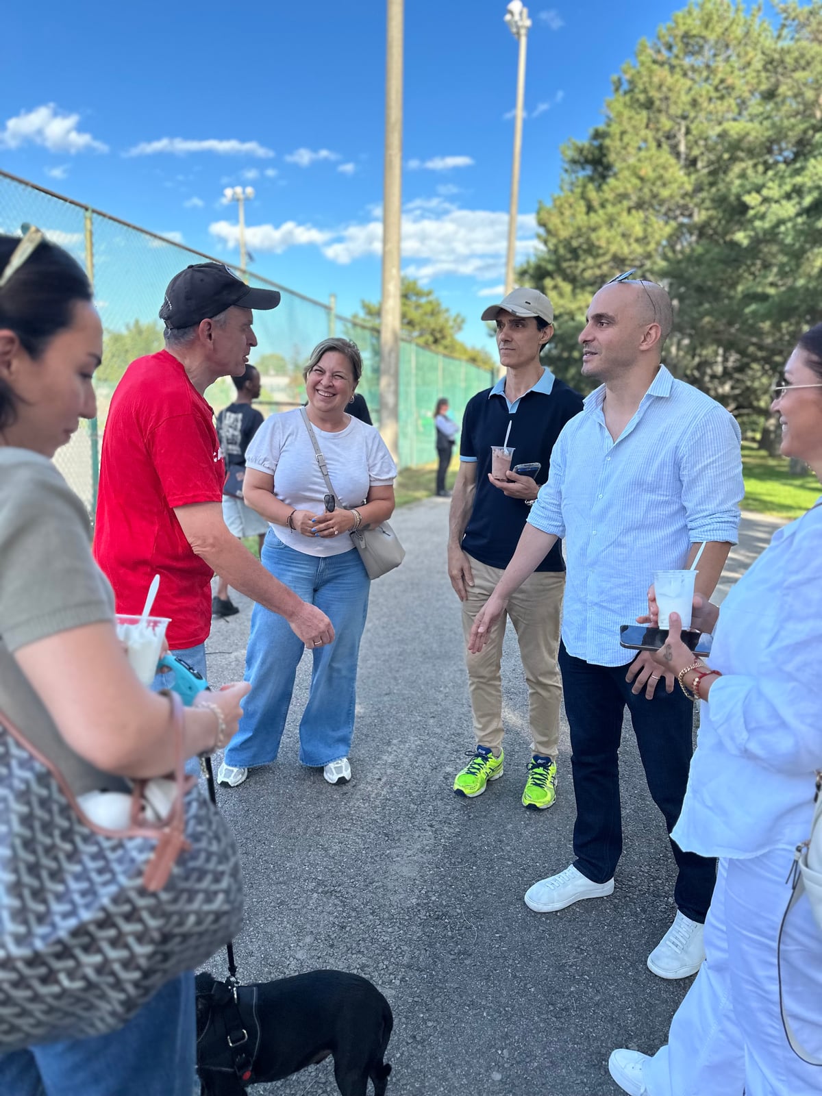 Sinan Erdemir in conversation with a group of neighbours at a park gathering