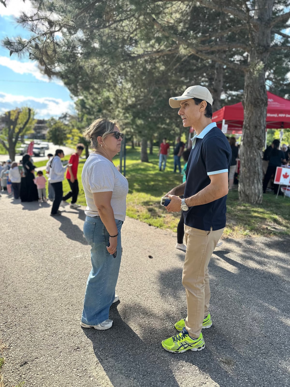 Sinan Erdemir listening to a resident at an outdoor community event