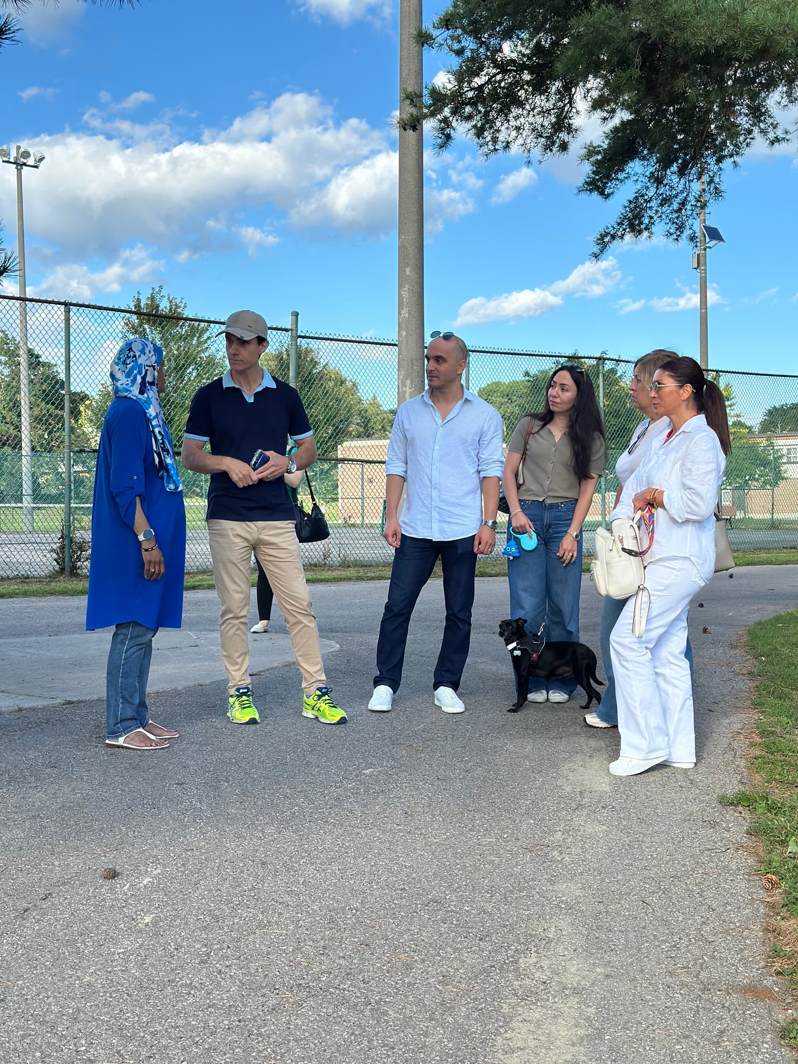 Sinan Erdemir speaking with a group of residents at a park event